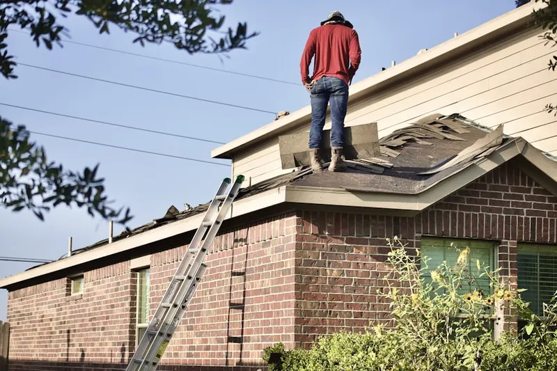 Professional roofer working on a residential roof in Taconic